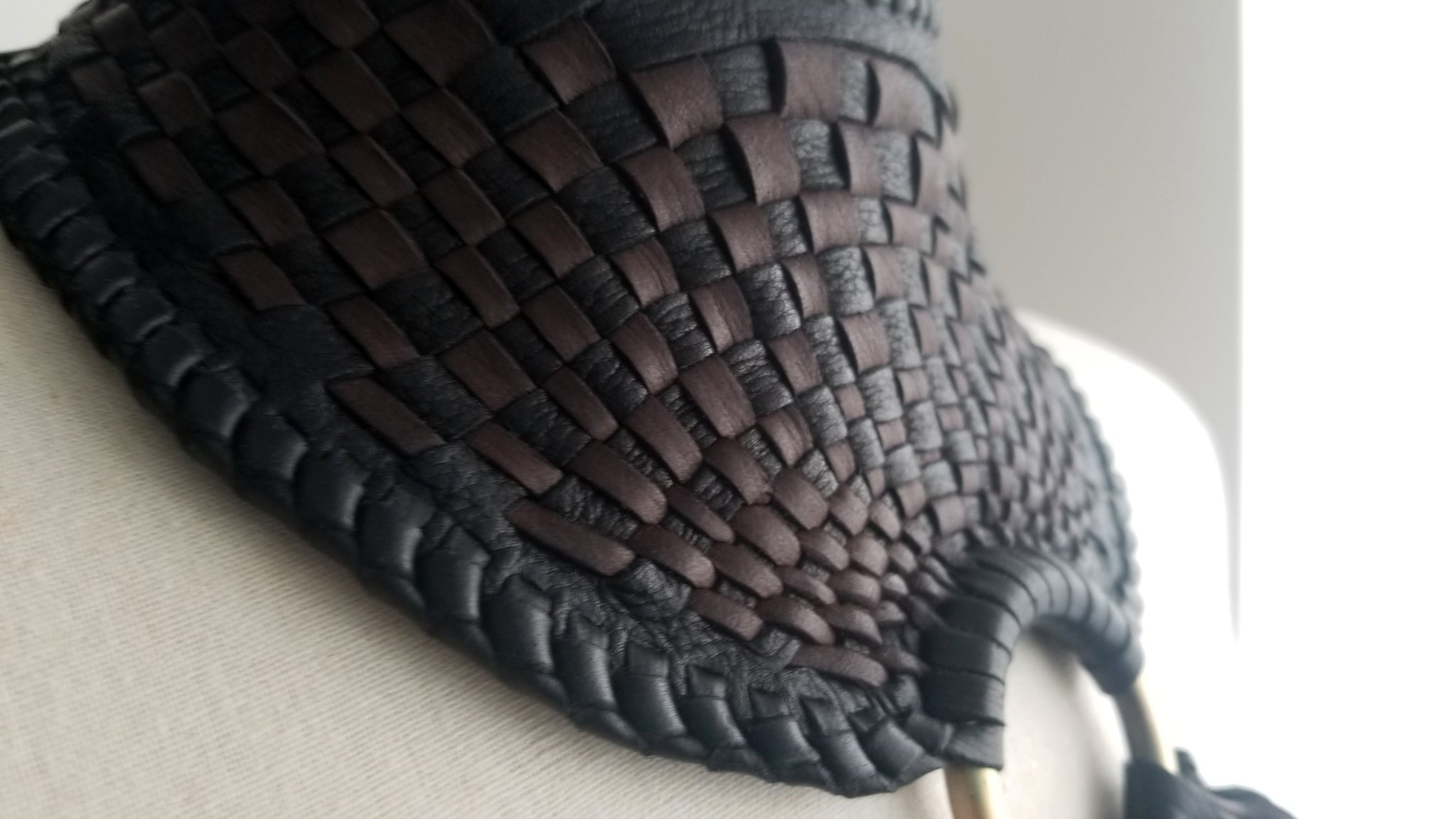 close up of the bib/collar of Zanta African Inspired, Braided Leather Statement Necklace, Bib Neckpiece, woven collar, fringe and tassels, on a dress form