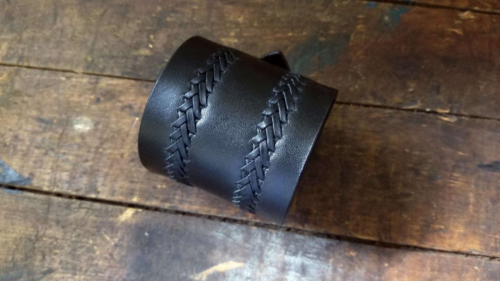2 rows of a ladder stitch hand lacing detail on Aga, Men's Wide Buckle Leather Cuff, in black