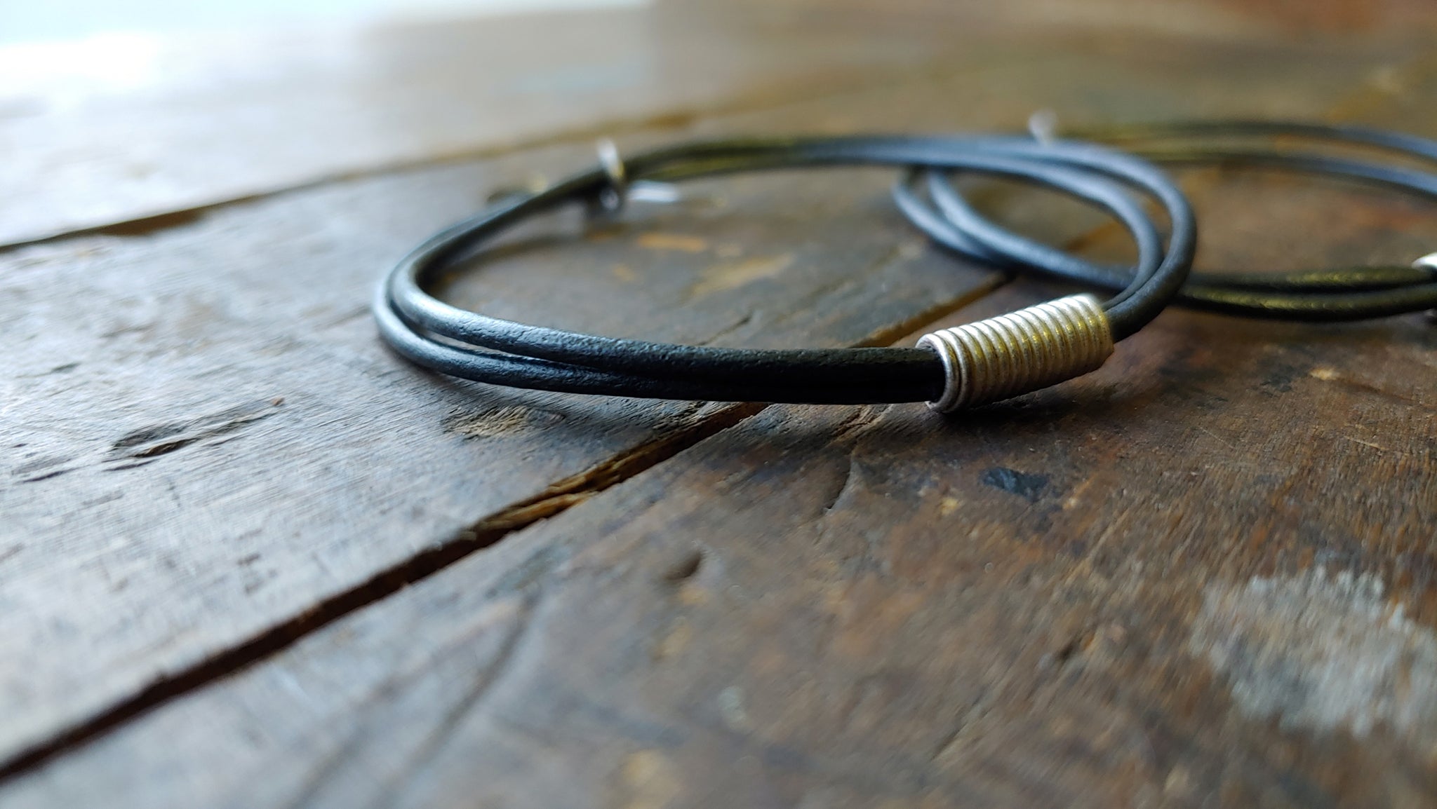 Oki leather cord earrings with handmade silver African spiral beads in gunmetal metallic round leather cord