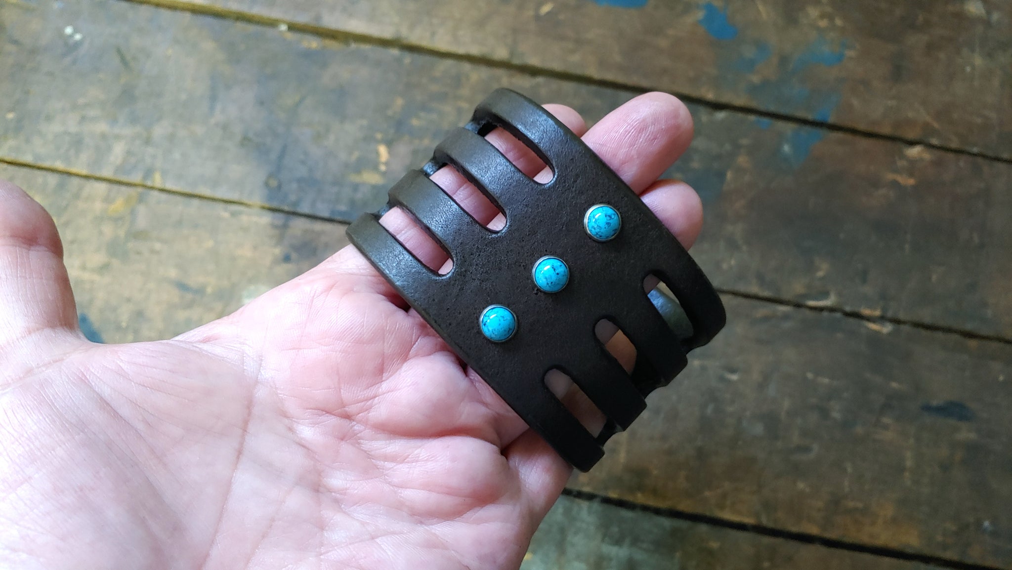 holding in hand Trinity wide Leather Cuff, Chocolate Brown with Turquoise rivets